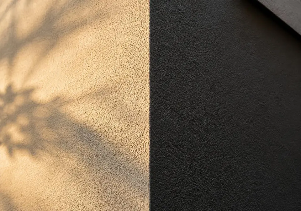 Close-up of coarse acrylic render texture in ivory and charcoal